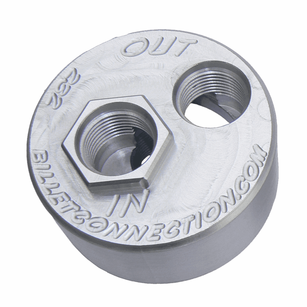 A round metallic component with two hexagonal openings and labeled text.