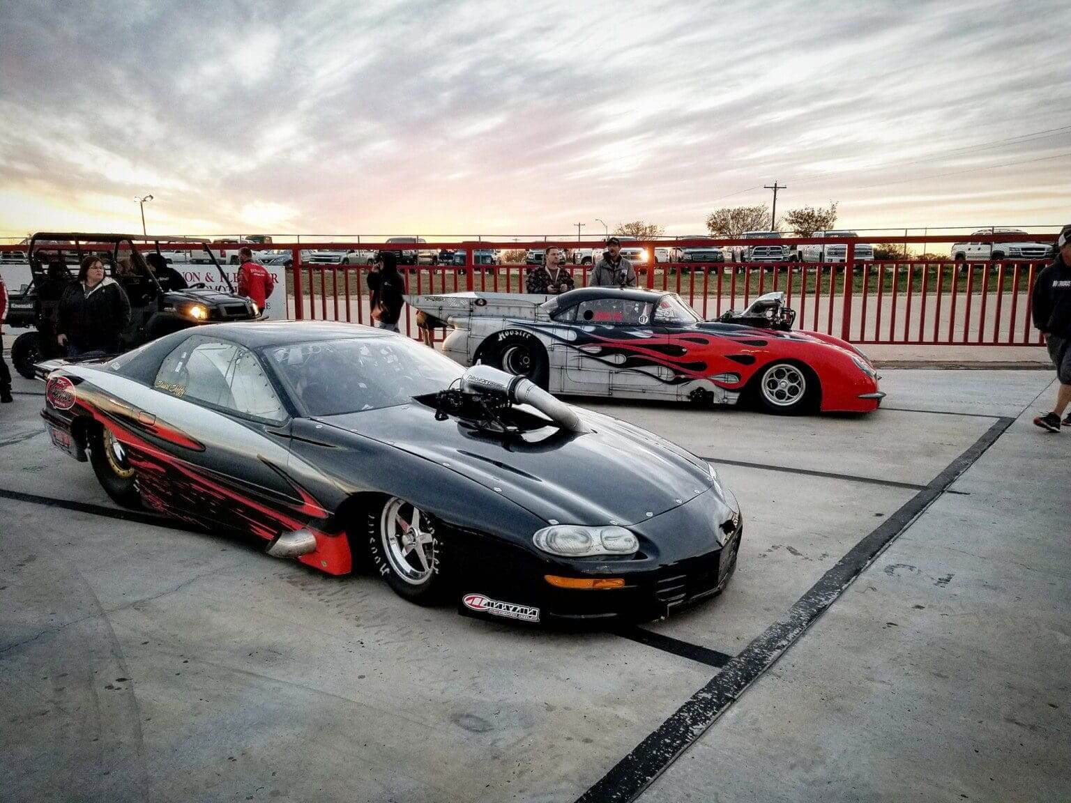 Two sleek sports cars parked side by side at sunset.