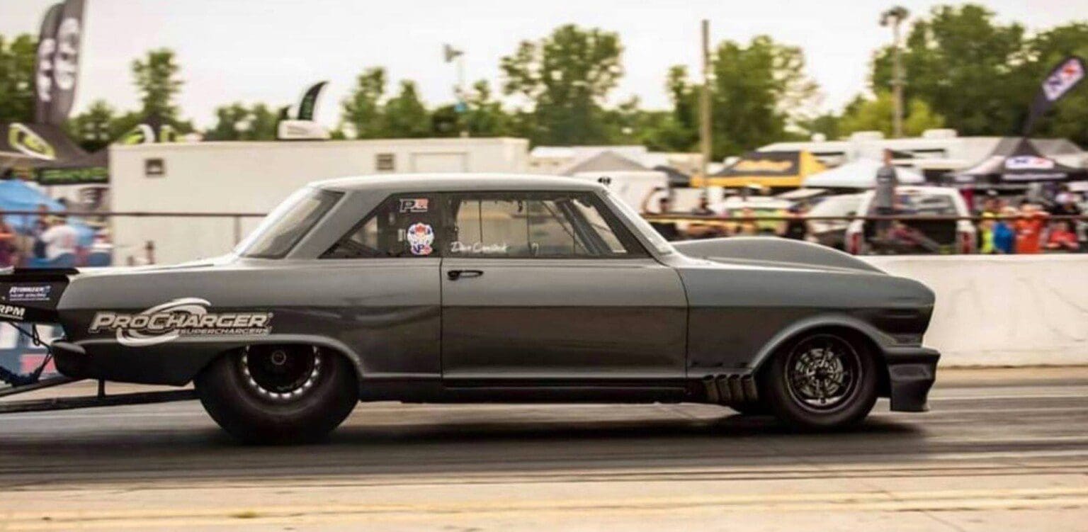 A vintage gray car with black wheels parked outdoors.