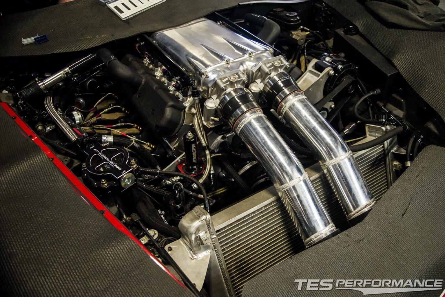 Close-up of a polished engine setup with twin exhaust pipes and intercooler.