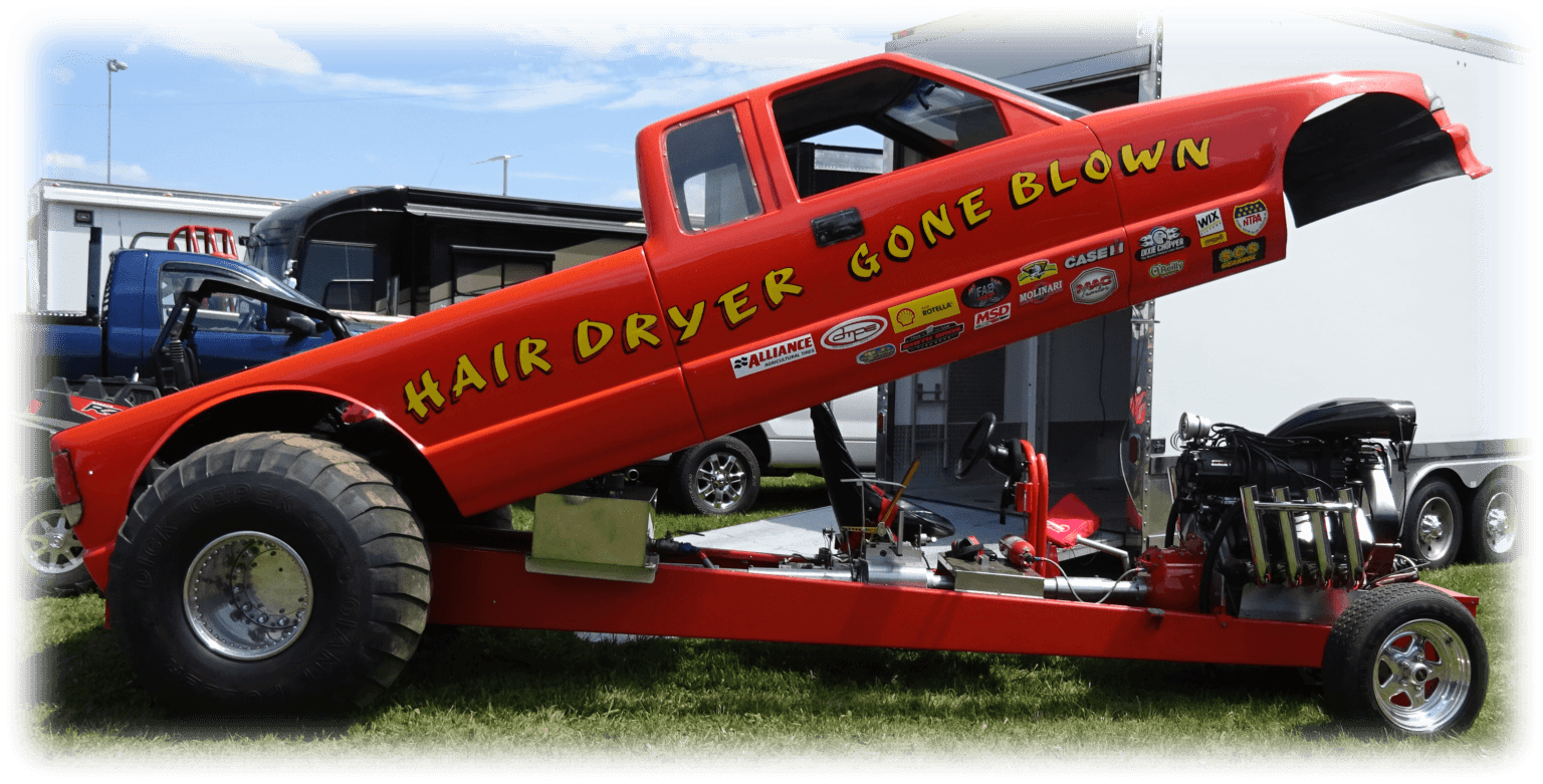 A giant red hair dryer sculpture mounted on a vehicle.